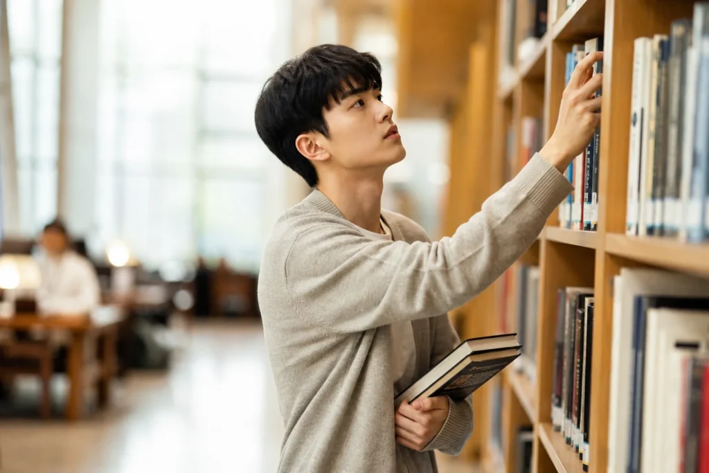 도서관에서 스스로 자료를 찾으며 능동적으로 학습하는 복수전공 학생 주도적인 연구와 학습 태도.